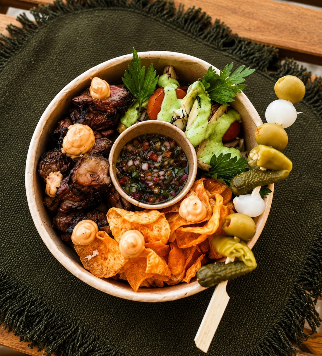 Bowl de street food com espetos de carne, farofa, chips e chimichurri